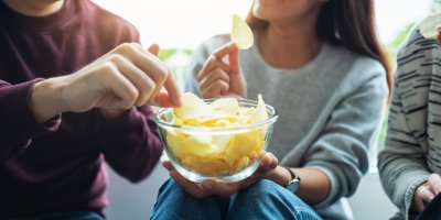 Skupina lidí se dělí o misku chipsů