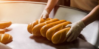 Pekař drží chleby 