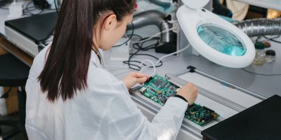 Žena ve fabrice vyrábí elektronický čip