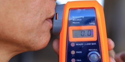 Muž používá alkohol tester v autě