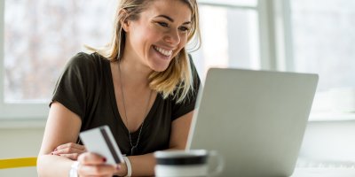 Žena s kreditkou nakupuje přes notebook