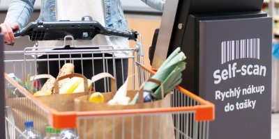 Zákaznice s plným nákupním vozíkem využívá samoobslužnou pokladnu Self-scan