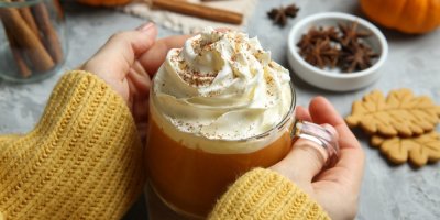 Šálek pumpkin spice latté se šlehačkou a skořicí