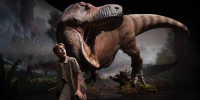 Chlapec stojící před dinosaurem v životní velikosti 
