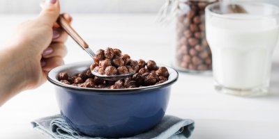 Žena snídá čokoládové kuličky s mlékem