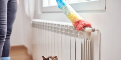 Žena utírá prach na radioátoru