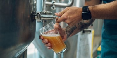 Muž čepuje pivo ze sudu