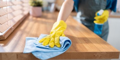 Člověk utírá kuchyňskou linku hadrem