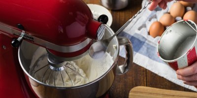 Žena připravuje těsto s kuchyňským robotem