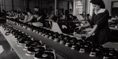 Dobová fotografie žen montujících žehličky v továrně ETA