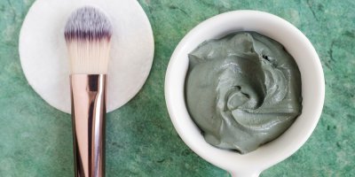 Zelený jíl rozmíchaný pro aplikaci pleťové masky