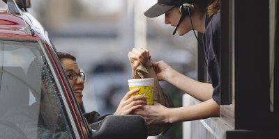 V drive-in podává prodavačka jídlo do auta