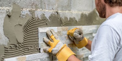 Muž připevňuje kachličky