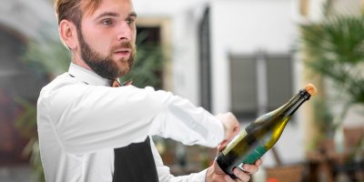 Barman otvírá lahev sektu