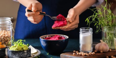 Žena maže řepovou pomazánku na celozrnný chleba