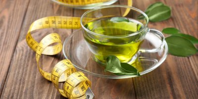 Zelený čaj v průhledném hrnku, krejčovský metr