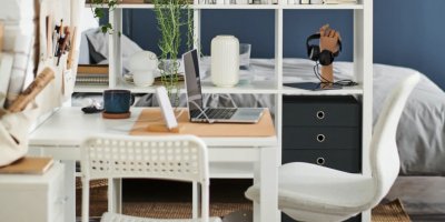 Pracovní stůl, který je oddělen od postele policovým dílem