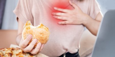 Žena jí hamburger a pálí ji žáha