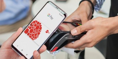 Žena platí stravenkovou kartou uloženou v mobilním telefonu