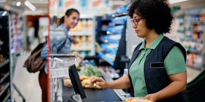 Prodavačka skenuje u kasy položky nákupu.
