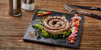 Opečená vinná klobása na černém tácu s oblohou