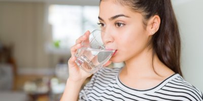 Žena pije vodu ze sklenice