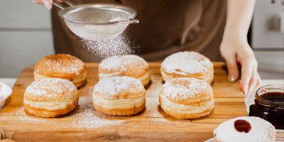 Člověk cukruje šest domácích koblih