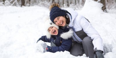 Žena s dítětem sedící ve sněhu