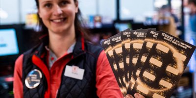 Žena drží v ruce sběratelskou kartičku sbírky pro Světlušku 