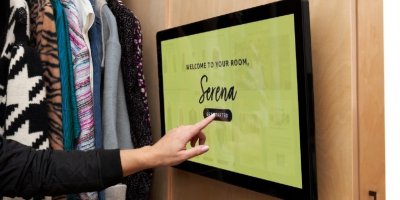 Žena si v kabince pomocí aplikace StyleSnap vybírá zboží