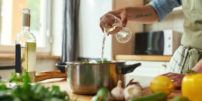 Kuchař nalévá do hrnce bílé víno