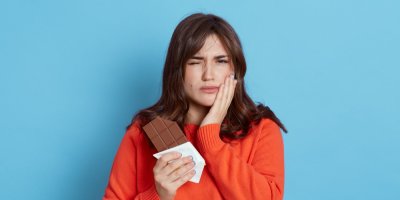 Ženu bolí zub po kousnutí do čokolády
