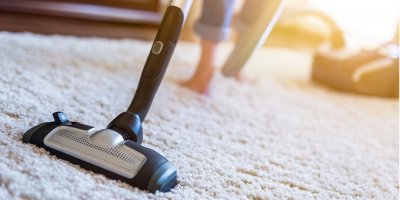 Žena vysává koberec