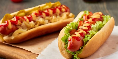 Dva hot dogy s hořčicí a kečupem