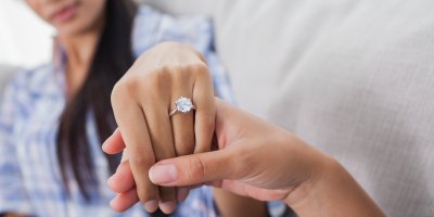 Žena natahuje ruku tak, aby byl vidět její zásnubní prsten s velkým kamenem