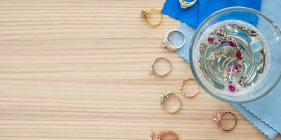 Hromádka prstýnků kolem a vně skleničky s čisticím roztokem