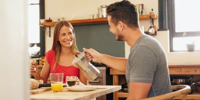 Pár si dává snídani a muž nalévá kávu z moka konvičky