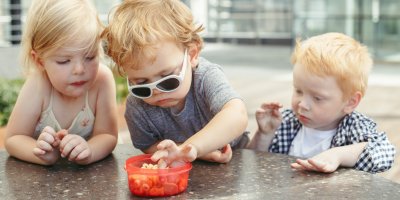 Tři děti si berou krekry z mističky