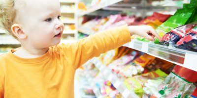 Malé dítě sahá na zboží v regálu