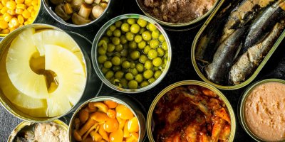 Otevřené konzervy s hráškem, ananasem, rybami nebo houbami