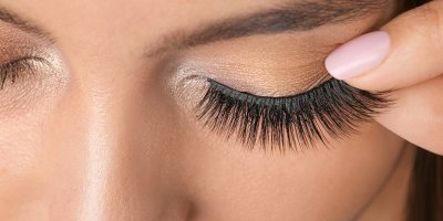 Žena si na oko aplikuje umělé řasy