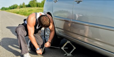 Muž nadzvedává auto pomocí heveru