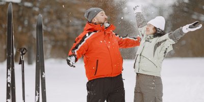 Muž se ženou v zimním oblečení a s lyžemi