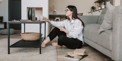 Žena sedí v obýváku a pracuje na počítači