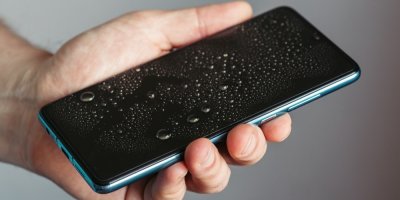 Ruka držící mokrý mobil