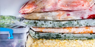 Různé druhy zeleniny v sáčcích na sobě v mrazáku