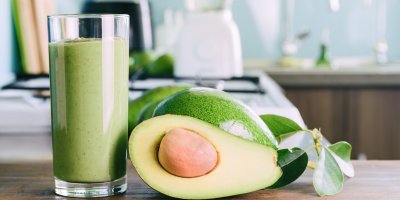 Zelené smoothie, avokáda v celku a rozpůlené avokádo