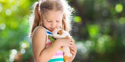 Dívka drží morčátko v náručí