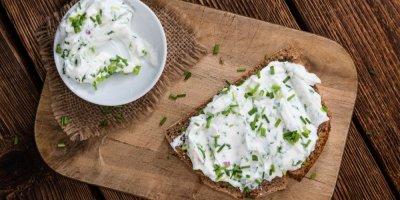 Tvarohová pomazánka s pažitkou v misce a na chlebu