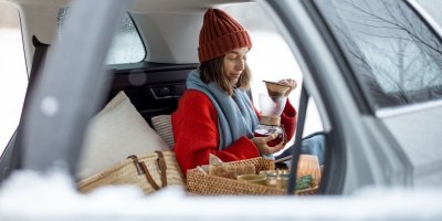 Žena si v autě připravuje překapávanou kávu